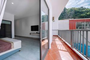 a bedroom with a balcony with a bed and a tv at catba new city hotel in Cat Ba