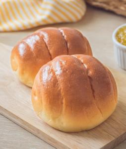 two buns sitting on a wooden cutting board at SHELTER HOTEL in Lucknow
