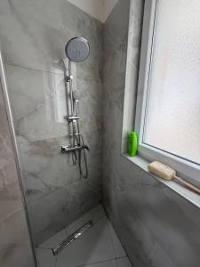 a shower with a glass door in a bathroom at Blue luxury apartment Kune in Sakës +20 photos