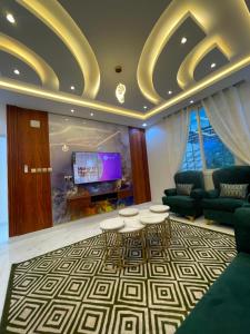 a living room with a couch and tables and a tv at شالية خاص in Khamis Mushayt