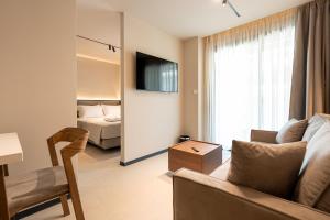 a living room with a couch and a bed at AVAIA boutique hotel in Nea Moudania