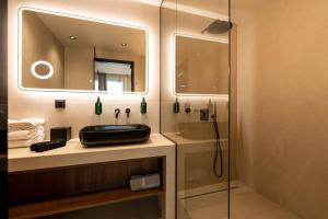 a bathroom with a sink and a shower at AVAIA boutique hotel in Nea Moudania +112 photos
