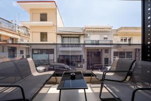 a balcony with chairs and a table and a building at AVAIA boutique hotel in Nea Moudania