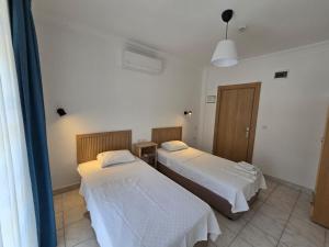 a room with two beds and a window at Golden Pension in Patara