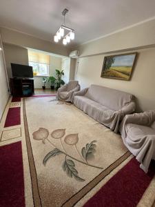 a living room with a couch and a rug at Bishkek Apartment Central in Bishkek
