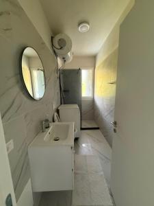 a bathroom with a sink and a mirror at Shengjin Apartament 5 M in Shëngjin +13 photos