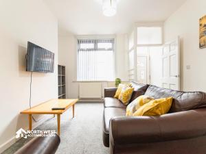 a living room with a leather couch and a table at Modern 2-Bedroom Home in Bolton Spacious & Comfortable in Bolton
