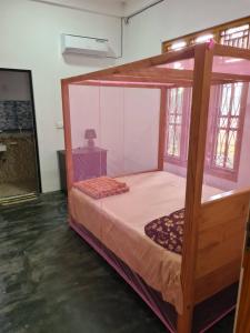 a bedroom with a wooden bunk bed in a room at Kanthans Lighthouse Cabanas in Komari