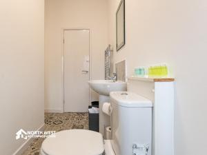 a bathroom with a toilet and a sink at Modern 2-Bedroom Home in Bolton Spacious & Comfortable in Bolton +19 photos