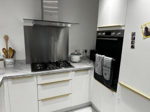 a kitchen with white cabinets and a stove top oven at Dzingai Home in Newport