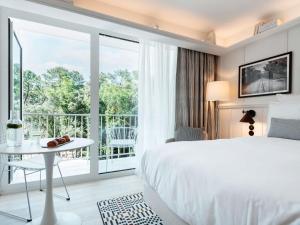 a hotel room with a bed and a balcony at Bel Hôtel Oléron Thalasso & Spa - MGallery Collection in Saint-Trojan-les-Bains +135 photos