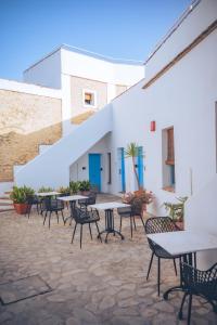 a patio with tables and chairs in front of a building at Hotel Utopía by MA 22 Puntos in Benalup Casas Viejas