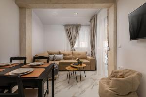 a living room with a table and a couch at Kreka Apartments in Pefkochori