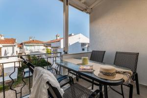 a patio with a table and chairs on a balcony at Kreka Apartments in Pefkochori