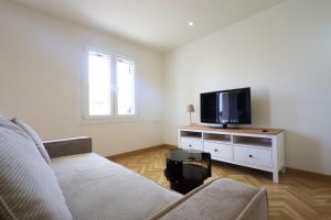 a living room with a couch and a flat screen tv at Family House in Lakones in Paleokastritsa