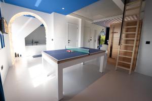 a room with a ping pong table in it at Capsule Santorini - balneo - Sauna - Switch 2 in Limelette