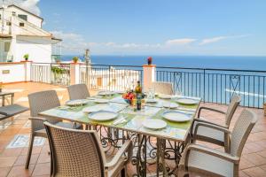 a table on a balcony with a view of the ocean at Terrazza di Rosa - sea view in Praiano