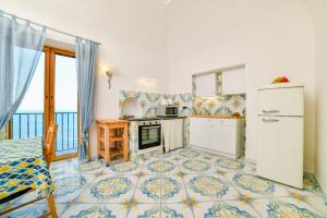a kitchen with a stove and a refrigerator at Terrazza di Rosa - sea view in Praiano
