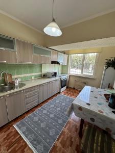 a large kitchen with a table and a table sidx sidx sidx at Bishkek Apartment Central in Bishkek