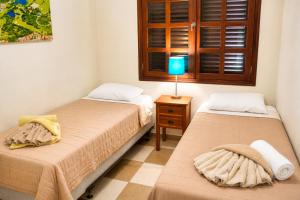 a bedroom with two beds and a lamp on a table at POCO POCO Villa - Poolside Golf & Beachfront Resort in Dorp Sint Michiel