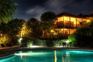 a house with a swimming pool at night at POCO POCO Villa - Poolside Golf & Beachfront Resort in Dorp Sint Michiel +9 photos