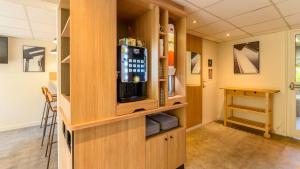 a room with a tv in a wooden cabinet at Premiere Classe Lyon Ouest - Tassin in Tassin-la-Demi-Lune