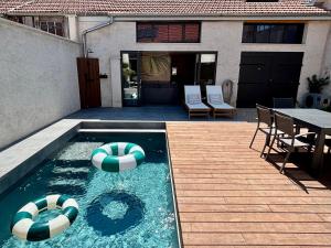 a swimming pool with two beach balls in a backyard at Appartement avec jacuzzi et piscine sur les remparts in Langres +5 photos