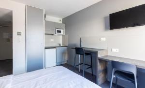 a kitchen with a counter and chairs in a room at Vacancéole - Le Terral - Montpellier Sud in Saint-Jean-de-Védas