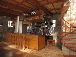 a kitchen with a bar with wooden tables and chairs at Refugio de Montaña Placaroja in San José de Maipo