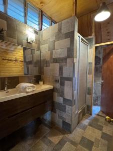 a large bathroom with a sink and a shower at Refugio de Montaña Placaroja in San José de Maipo
