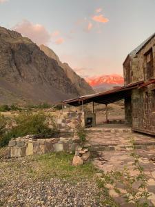 a stone building with mountains in the background at Refugio de Montaña Placaroja in San José de Maipo