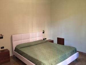 アルバ・アドリアティカにあるAppartamenti Medusaのベッドルーム1室(緑色のベッドカバー付きの大型ベッド1台付)