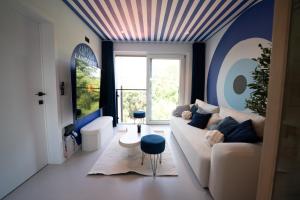 a living room with a couch and a large window at Capsule Santorini - balneo - Sauna - Switch 2 in Limelette