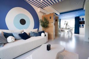 a living room with a white couch and a blue wall at Capsule Santorini - balneo - Sauna - Switch 2 in Limelette
