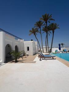 a resort with palm trees and a swimming pool at Maison Rachid Djerba in El Guecheïne +4 photos