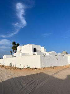 a white building on the side of a road at Maison Rachid Djerba in El Guecheïne