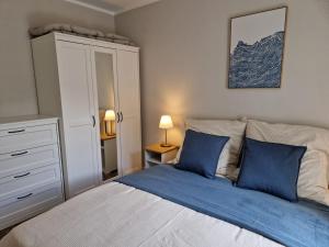 a bedroom with a bed with blue pillows at FeWo Gisa - Graal Müritz in Graal-Müritz