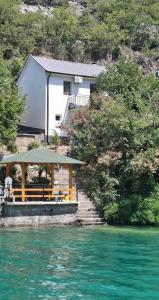 a house with a gazebo next to the water at Mostar kuca pored jezera in Mostar