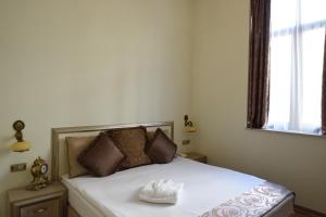 ブカレストにあるEuro Hotel Grivitaのベッドルーム(ベッド、帽子付)
