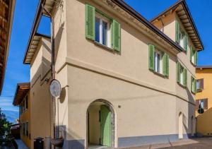 a building with green shuttered windows and a doorway at La Corte del Lario - Contrada Vecchia in Varenna