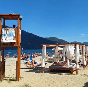 a group of people laying on the beach at Appartamento AZZURRO in Cannobio