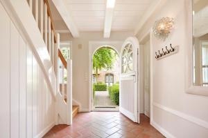a hallway with an arched entry way with a door at Friesen-Kate-Oldsum in Oldsum