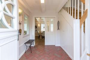 a hallway with a white door and a staircase at Friesen-Kate-Oldsum in Oldsum
