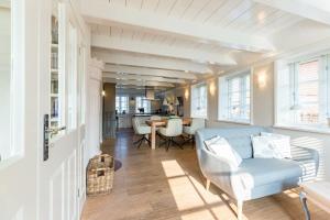 a living room with a blue couch and a table at Friesen-Kate-Oldsum in Oldsum