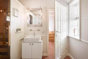 a bathroom with a white sink and a mirror at Friesen-Kate-Oldsum in Oldsum