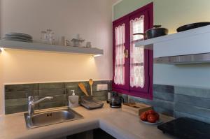 a kitchen with a sink and a red window at Nefeli Hotel Leros in Agia Marina +151 photos