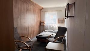 a small room with a bed and two chairs at Pěkná Vyhlídka in Závažná Poruba