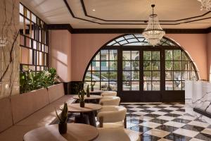 ein Restaurant mit Tischen und Stühlen und einem großen Fenster in der Unterkunft Mural Piraeus Hotel in Piräus + 76 Fotos