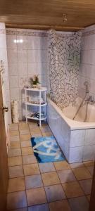a bathroom with a tub and a tiled floor at Fewo am Wasserrad in Ruhla