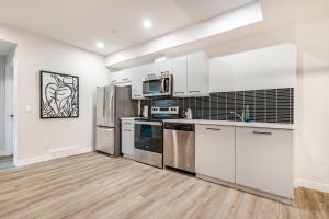 a kitchen with white cabinets and stainless steel appliances at Hotchlair Private Suite with Kitchen, Dining & Cozy Living Area in Calgary